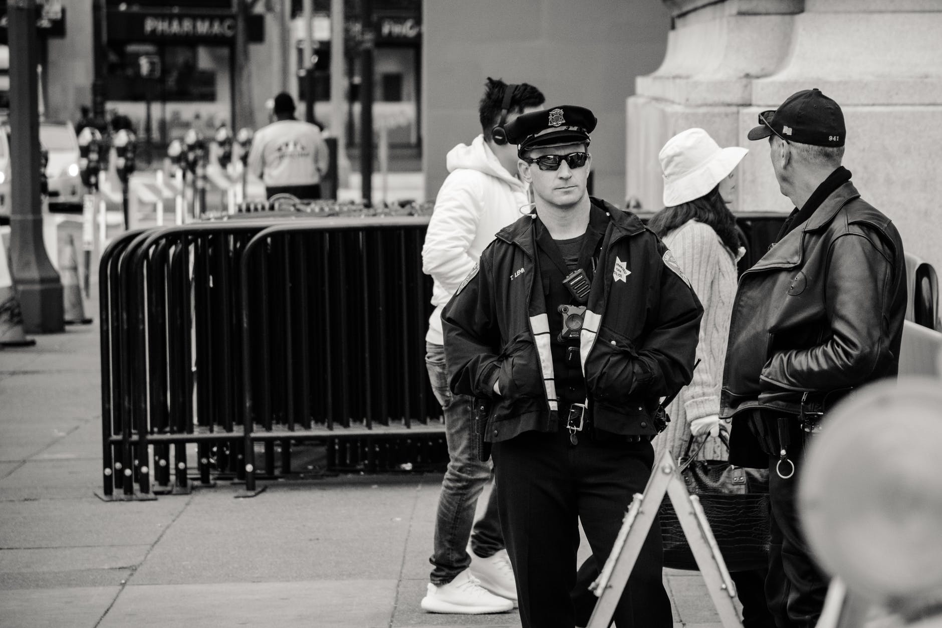 man wearing jacket and peaked cap grayscale photo