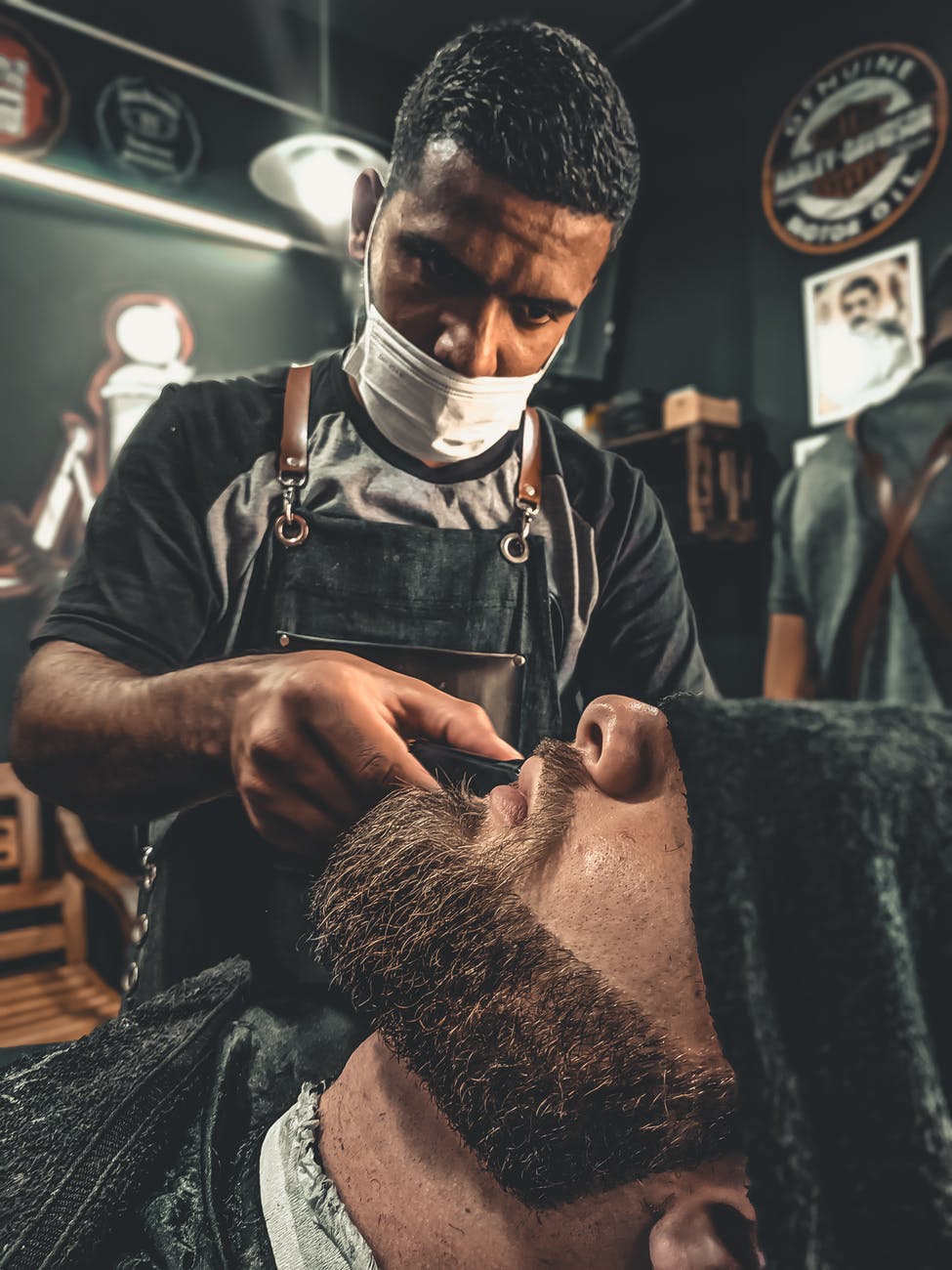 a barber grooming a man s beard