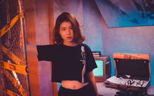 woman wearing crop top standing near wire fence