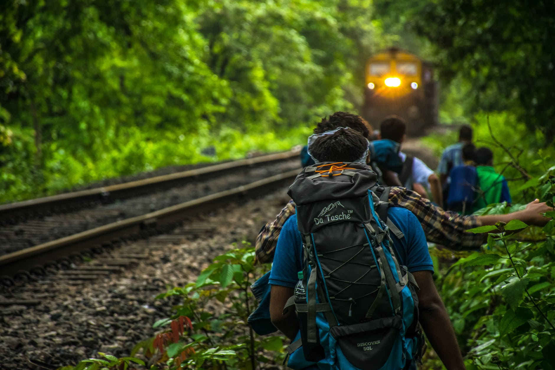 group of people walking beside train rail